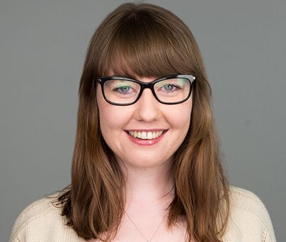 Annabel Murphy-Fegan Smiling woman with black glasses and brown, shoulder length hair, wearing a cream sweater.