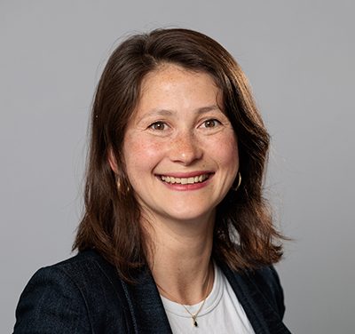 Julie-Anne Tangena Image of a smiling woman with short brown hair and brown eyes wearing a black blazer and a white t shirt