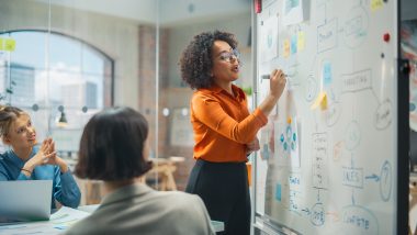 Woman writing on white board in conference room